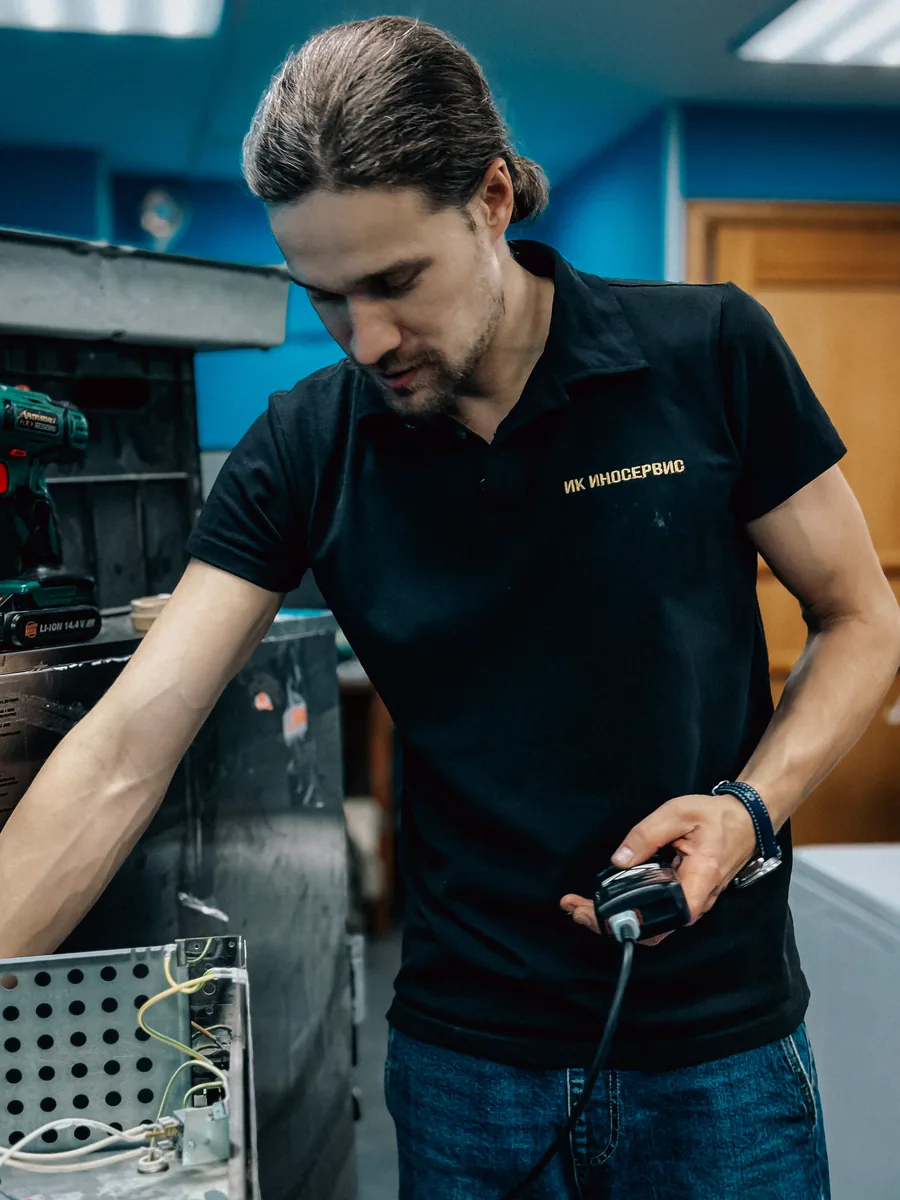 Técnico testando um equipamento de cozinha com instrumento de medição