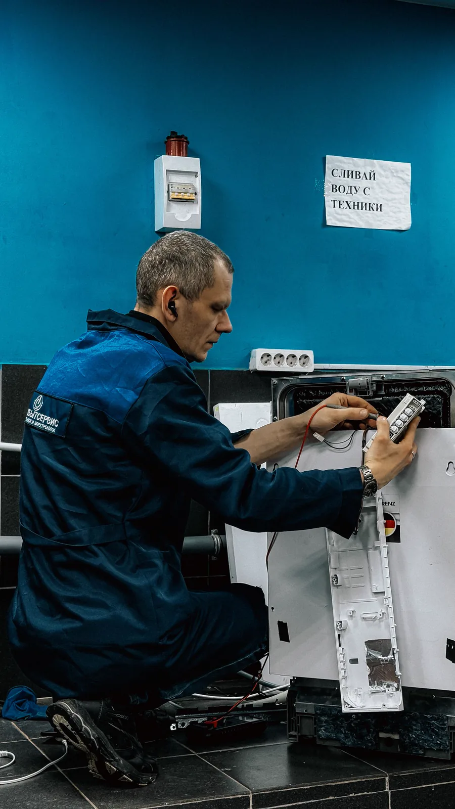 Técnico de uniforme fazendo manutenção em um eletrodoméstico
